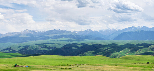 Obraz premium Grassland and mountains in a cloudy day. Photo in Kalajun grassland in Xinjiang, China.