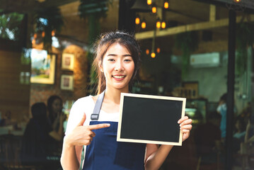 Barista asian women holding label Coffee order in the coffee shop. Service Concept