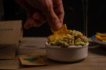 wooden table with wine nachos and guacamole in selective focus