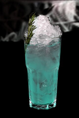 refreshing alcoholic drink with berries, ice vodka and gin, lemon peel served in glass cup on the counter on blurred background