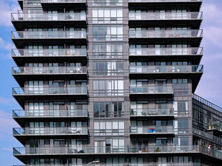 modern high rise apartment building with floor to ceiling windows and glass balcony railings for maximum access to sunlight © Spiroview Inc.