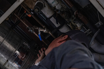 Technician Works on Pipes Overhead
