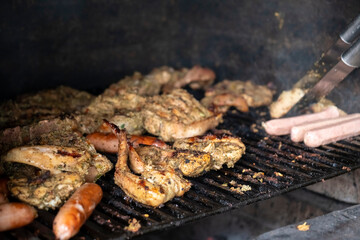 Traditional barbecue ( BBQ) on a brick and charcoal grill, with a variety of meats - pork, chicken...