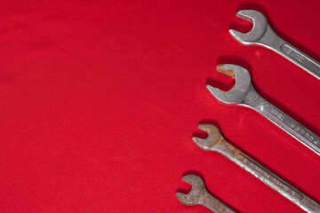 Wrenches, rusty, arranged in ascending order on a red background leaving space for advertising text. Construction tools
