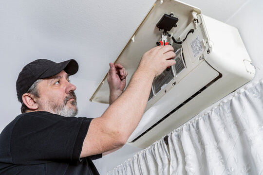 Technical professional in air conditioning changing the wifi command of an internal unit of a split air unit.