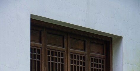 traditional old chinese style wooden window frames and cracked white wall