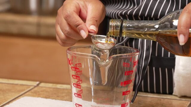 Making a homemade marinade with a base of sherry - measuring out a tablespoon into a mixing cup