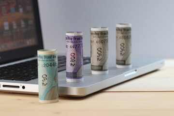 Indian currency notes with a laptop  computer.