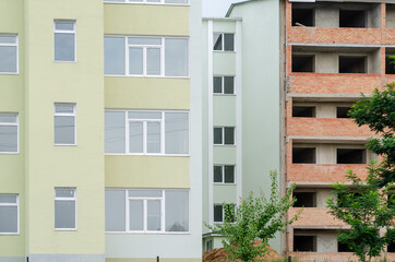 The facade of an unfinished apartment complex.  Red brick apartm
