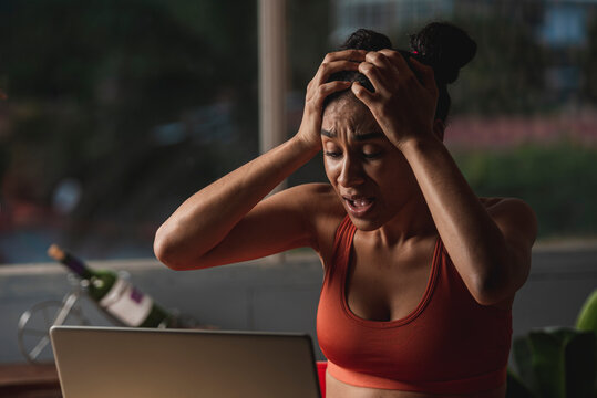 mujer morena sorprendida y muy asustada con su computadora haciendo tele trabajo 