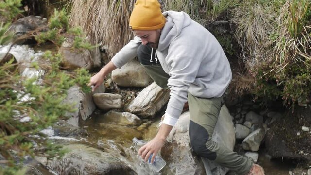 hiker collecting clean water from source
