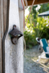 rustic and rusty antique bottle opener in the shape of a bottle in the backyard bar with vintage flair