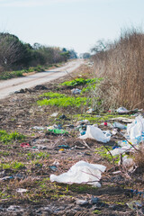 Plastic waste accumulated on the side of a rural road. Damage to the environment. Pollution by Garbage