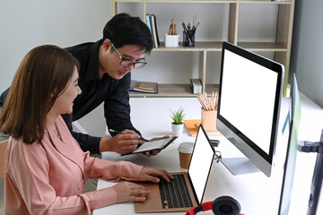 Two business colleagues using digital tablet to discussing information in modern office.