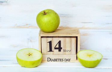 Wooden Calendar with the Date 14 November and Green Apples . World Diabetes Day Concept 