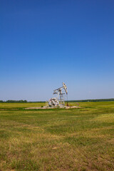 The rocking oil pumps stand in endless spaces. Individual mechanical sucker rod pump drive