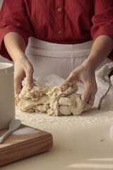 Woman with red dress making bread by kneading sourdough 