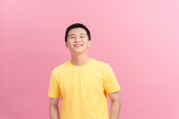 A man with a yellow t-shirt standing looking at the camera
