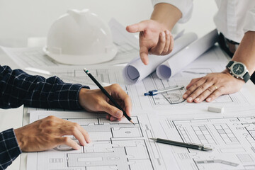 Two business man construction site engineers. working drawing on blueprint and discussing the floor...