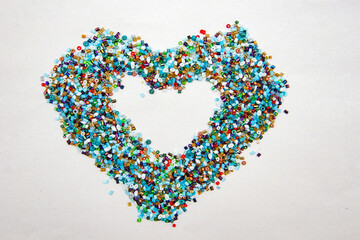 colorful beads scattered on a white background,  a heart of scattered colorful beads