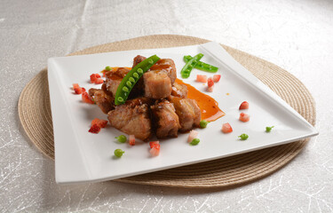 Stir fried dark plum sweet and coffee sauce pork spare ribs meat with almond in white background asian banquet menu