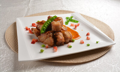 Stir fried dark plum sweet and coffee sauce pork spare ribs meat with almond in white background...