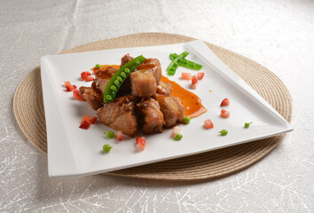 Stir fried dark plum sweet and coffee sauce pork spare ribs meat with almond in white background asian banquet menu