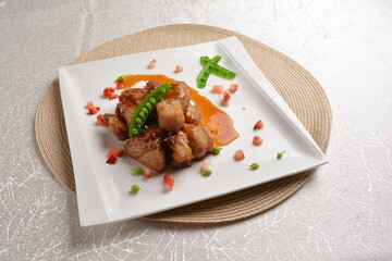 Stir fried dark plum sweet and coffee sauce pork spare ribs meat with almond in white background asian banquet menu
