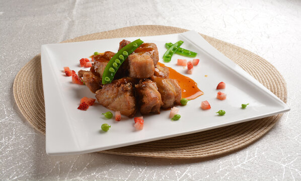 Stir fried dark plum sweet and coffee sauce pork spare ribs meat with almond in white background asian banquet menu