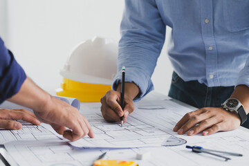 engineer meeting for an architectural project. working with partner and engineering tools working on blueprint architectural project at the construction site at desk in the office.