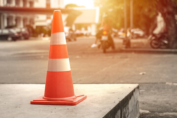 An orange traffic cone is placed on the side of the road.