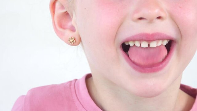 little girl show tongue saliva, throat. child do gymnastics. kid Training of muscles speech therapy. Happy baby on white background. Place for text. portrait with wide open mouth and protruding tongue