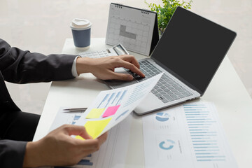 The businessman hand sits at their desks and calculates financial graphs showing the results of their investments planning the process of successful business growth