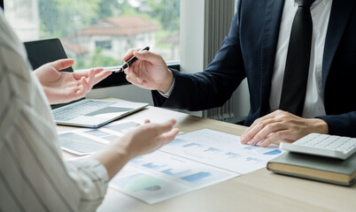 Two business leaders talk about charts, financial graphs showing results are analyzing and calculating planning strategies, business success building processes