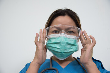 Medical Doctor/Nures in uniform ware protection equipment from pathogen. Medical staff in isolated background in hospital.