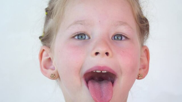 fly sat on forehead while girl stuck out tongue. funny child smiles and makes friends with insects. Summer in tree. Nature lovers club. Happy childhood. Cheerful little kid shows tongue, throat, teeth