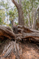 Male senior with a camera enjoying hobby photography outdoors while hiking in a forest