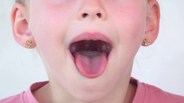 little girl show tongue, throat. child do gymnastics. kid Training of muscles speech therapy. Happy baby on white background. Place for text. portrait with wide open mouth and protruding tongue.