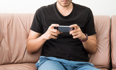 man using smart phone while relaxing on sofa. Concept of young business people working at home