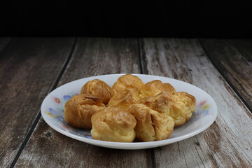 Pile of Choux cream serving on the plate. Classic sweet dessert in party or ceremony.