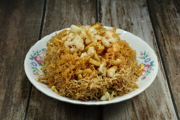 Traditional deep fried rice noodle (vermicelli) seasoning with sugar and topping with shrimp meat serving on the plate. Famous royal ancient menu in Asia.