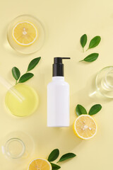 Fototapeta na wymiar Bottle of Natural beauty organic botany with lemon fruit scientific equipment researched cosmetic concept therapy on light yellow background. Top view. Copy space