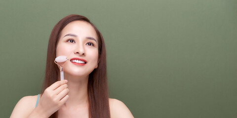 Obraz premium Woman using face roller For Face Massage