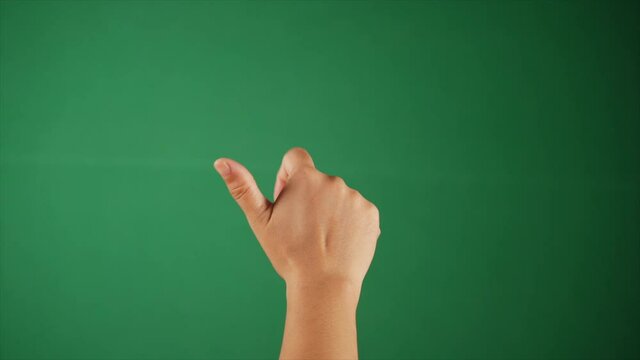 A young woman's hand counting with her five fingers over a green screen. Closeup shot of a raised human hand making a fist against a green background - Green chroma setup