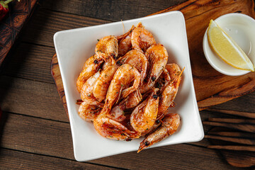 Roasted garlic shrimp appetizer with beer on wooden background