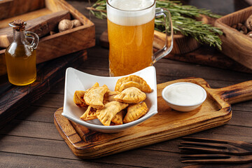 Plate of fried chebureks meat stuffed pies on wooden background