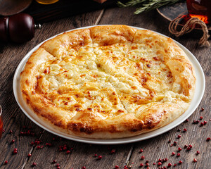 Megrelian khachapuri flat bread with cheese on wooden background