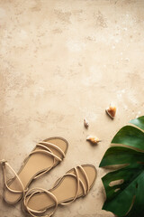 Summer sandals , seashells and palm leaf on sand concrete background for summer times and travel concept. Copy space