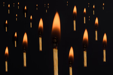 Creative concept of light in the dark. Lighted matches floating. Isolated in black background. 