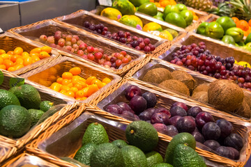 Fruit market with various colorful fresh fruits and nuts in baskets